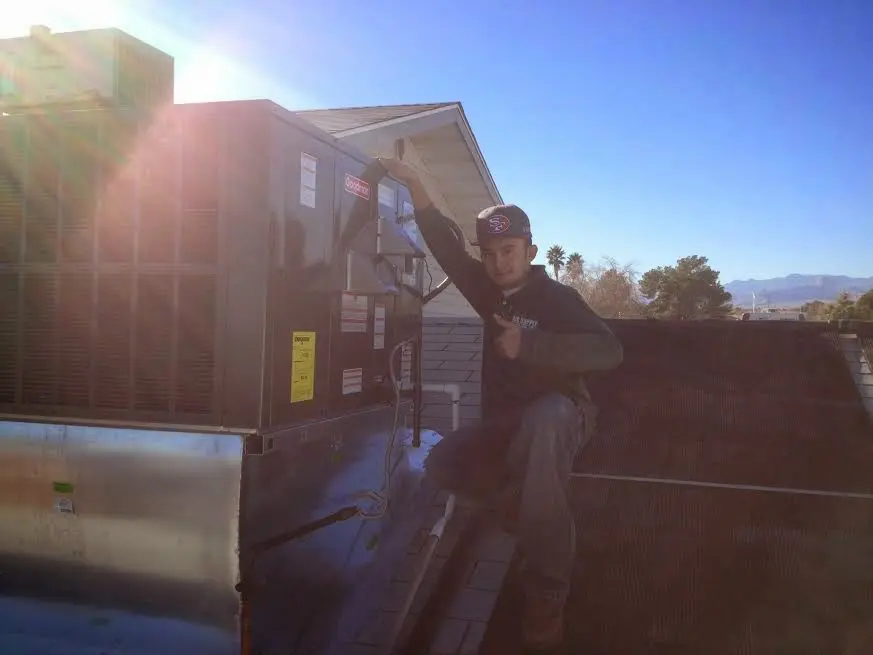 HVAC technician performing Air Duct Cleaning on a rooftop unit in Egelston